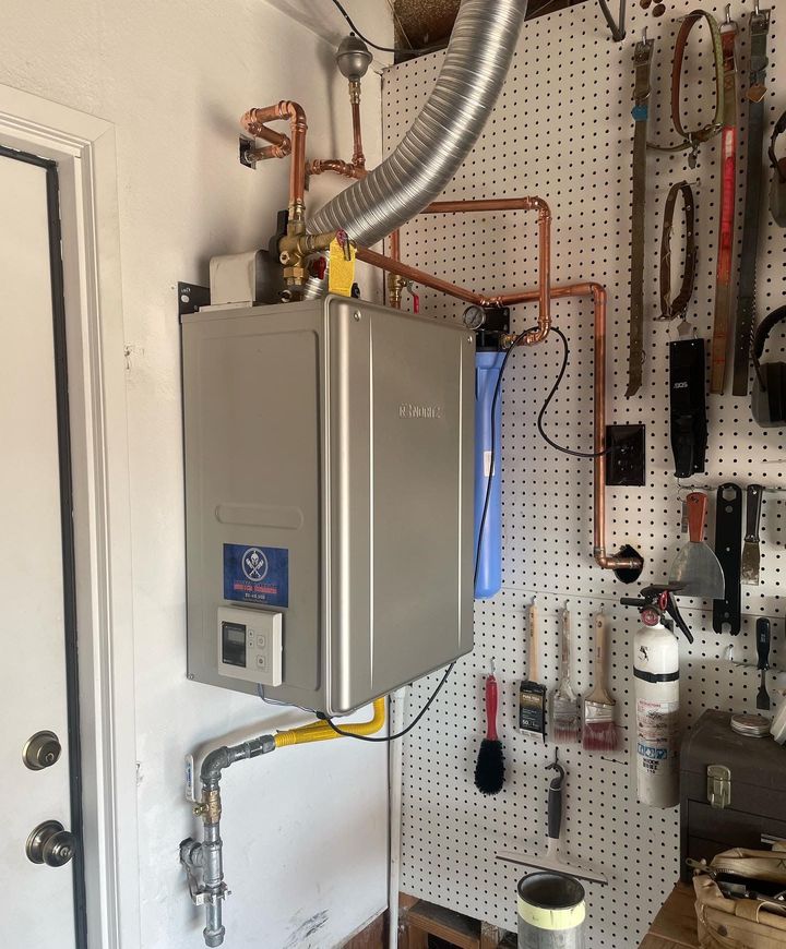 Tankless water heater installed on a garage wall with new copper and gas lines